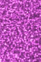 Blurred pink decorative sequins. Background image with shiny bokeh lights from small elements photo