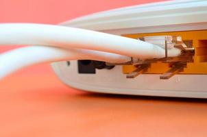 The Internet cable plugs are connected to the Internet router, which lies on a bright orange background. Items required for Internet connection photo