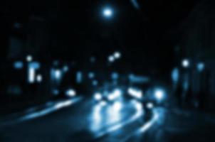 escena nocturna borrosa de tráfico en la carretera. imagen desenfocada de coches que viajan con faros luminosos. arte bokeh foto