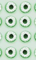 Many small plastic donuts lies on a pastel colorful background. Flat lay minimal pattern. Top view photo