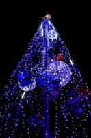 Fragment of the New Year tree. A lot of round lights of blue color are located on a conical frame photo