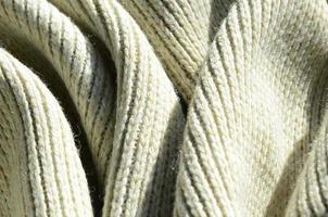 Fabric texture of a soft yellow knitted sweater. Macro image of the structure of bindings in yarns photo