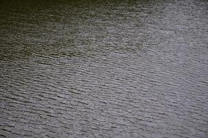 The texture of dark river water under the influence of wind, imprinted in perspective. Horizontal image photo