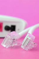 Internet router and Internet cable plugs lie on a bright pink background. Items required for Internet photo