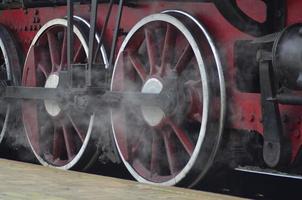 Red wheels of steam train photo