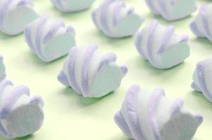 Colorful marshmallow laid out on lime paper background. pastel creative textured pattern photo