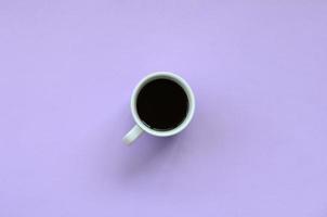 Small white coffee cup on texture background of fashion pastel violet color paper in minimal concept photo