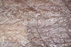 Texture of white crumpled cellophane surface transparent on sunlight. Concept of materials for packaging, product protection against damage photo