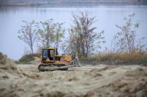 Quarry aggregate with heavy duty machinery. Caterpillar loader Excavator with backhoe driving to construction site quarry photo