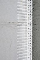 The texture of the wall, covered with gray polystyrene foam plates, which are coated with a reinforcing mixture with a plastic reinforcing profile corner. Stage of wall insulation photo