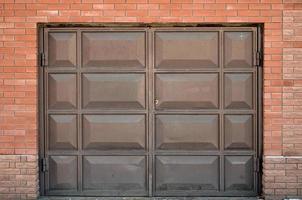 The texture of a painted metal gate from a brick garage photo