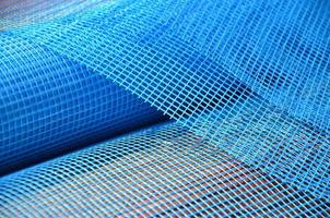 Close-up texture of a blue reinforcing mesh rolled up in a roll. Building resource for reinforcing walls in the process of their warming photo