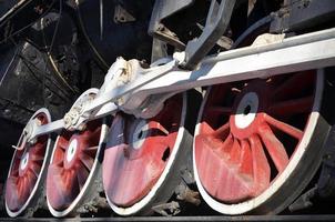 Red wheels of steam train photo