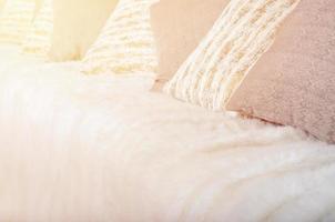 Many pillows lie on the couch, which is covered with a large plush veil photo