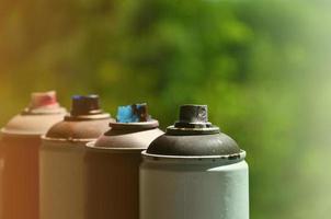 A few used aerosol paint sprayers lie on the windowsill in the workshop of a graffiti artist. The concept of street art and illegal drawing on the walls. Youth hobby photo