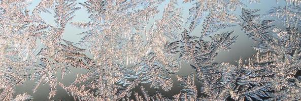 Snowflakes frost rime macro on window glass pane photo