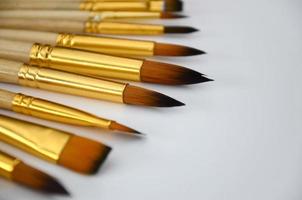 A selection of orange brushes with different sizes on a white surface photo