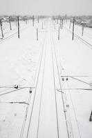 paisaje ferroviario de invierno, vías férreas en el país industrial cubierto de nieve foto