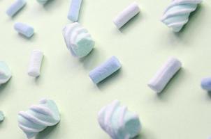 Colorful marshmallow laid out on lime paper background. pastel creative textured pattern photo