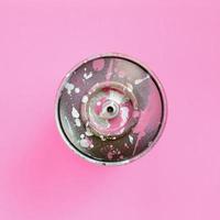 Used spray can with pink paint drips lie on texture background of fashion pastel pink color paper in minimal concept photo