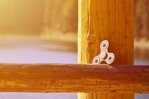 A wooden spinner lies on a wooden bar against a background of river water photo