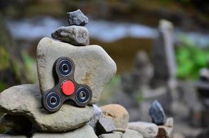 A wooden spinner lies on strange stone structures in the forest photo