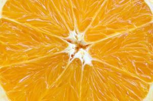 Top view of a fragment of the orange fruit slice close up. Macro background texture photo