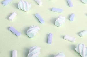 Colorful marshmallow laid out on lime paper background. pastel creative textured pattern photo