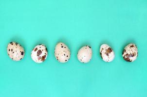Quail eggs on a light green surface, top view, empty place for text, recipe photo