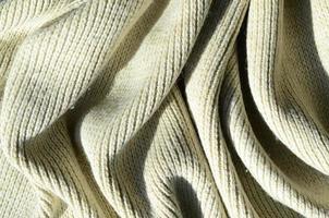 Fabric texture of a soft yellow knitted sweater. Macro image of the structure of bindings in yarns photo
