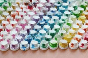 A pattern from a many nozzles from a paint sprayer for drawing graffiti, smeared into different colors. The plastic caps are arranged in many rows forming the color of the rainbow photo