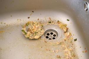 Close up on dirty clogging kitchen sink drain with food particles photo