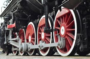 Red wheels of steam train photo