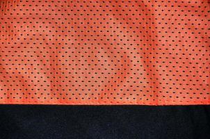 Red sport clothing fabric texture background. Top view of red cloth textile surface. Bright basketball shirt. Text Space photo