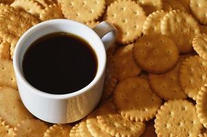 taza de café pequeña y galleta salada foto