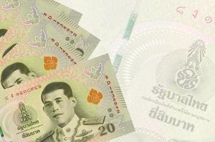 Los billetes de 20 baht tailandeses se encuentran apilados en el fondo de un gran billete semitransparente. fondo de negocios abstracto foto