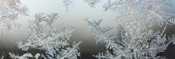 Snowflakes frost rime macro on window glass pane photo