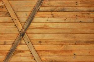 Texture of an old fence of horizontal orange wooden planks with cross-boards photo