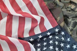 bandera de los estados unidos de américa y chaqueta de uniforme militar doblada. banner de fondo conceptual de símbolos militares para fiestas patrióticas americanas foto