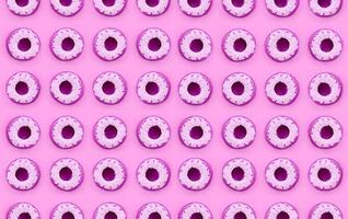 Many small plastic donuts lies on a pastel colorful background. Flat lay minimal pattern. Top view photo