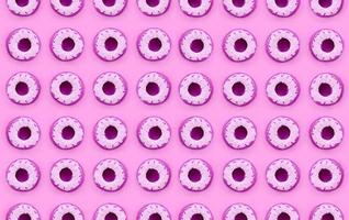 Many small plastic donuts lies on a pastel colorful background. Flat lay minimal pattern. Top view photo