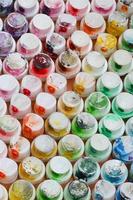 A pattern from a many nozzles from a paint sprayer for drawing graffiti, smeared into different colors. The plastic caps are arranged in many rows forming the color of the rainbow photo