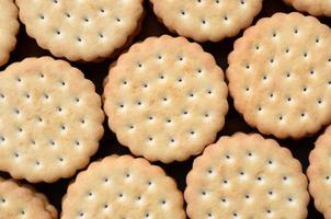 Detailed picture of round sandwich cookies with coconut filling. Background image of a close-up of several treats for tea photo