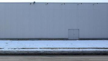 textura de una pared metálica alta de un edificio industrial sin ventanas foto