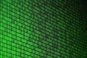 An image of a binary code made up of a set of green digits on a black background photo