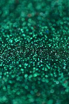 A huge amount of green decorative sequins. Background texture with shiny, small elements that reflect light in a random order. Glitter texture photo
