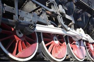 Red wheels of steam train photo