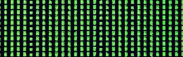 Macro shot of a glitch on the monitor of an office computer. The concept of introducing a virus into a personal data keeper. Stream of random green symbols on a black background photo