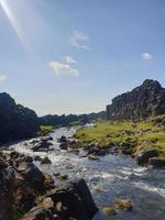 una gran cascada sobre un acantilado rocoso - oxarafoss en el parque nacional de Thingvellir. foto