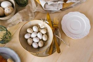 Easter table setting with eggs in a plate. Serving a festive breakfast or lunch. Flat lay photo